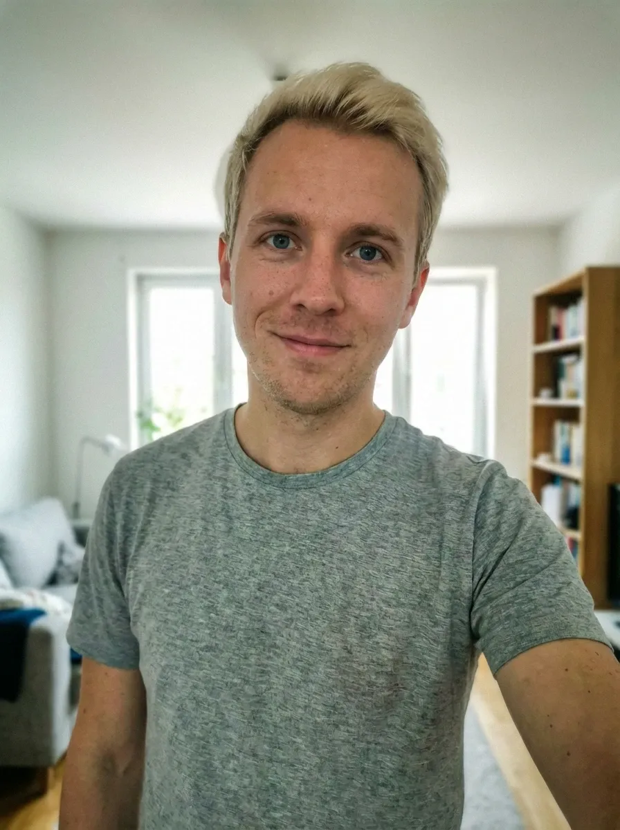 Home selfie of a blond man in a gray T-shirt